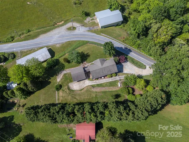 an aerial view of a house with a garden and lake view