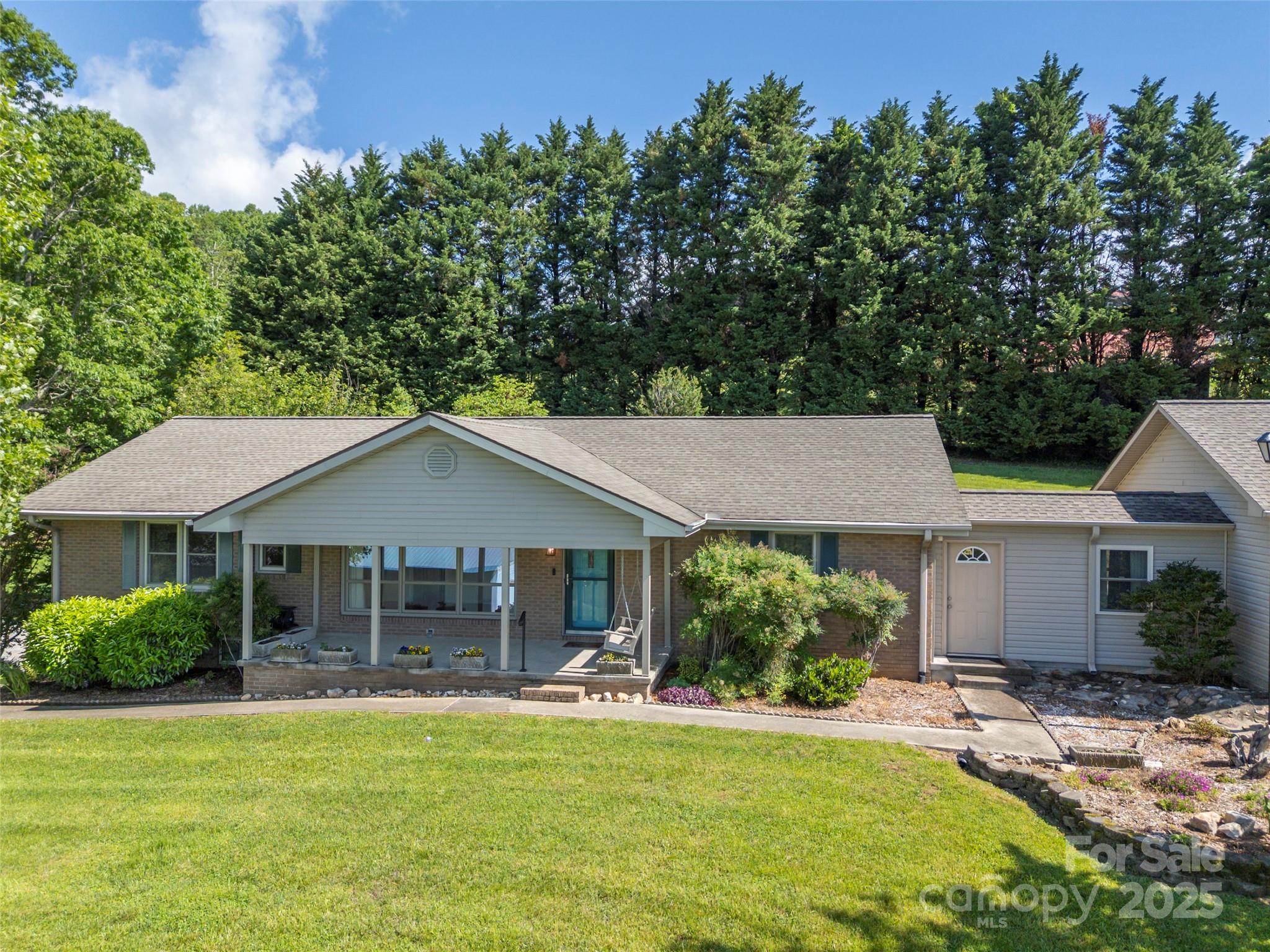 418 Mountain Page Road Saluda, NC 28773 - Photo 5 of 48 a front view of a house with a garden and porch