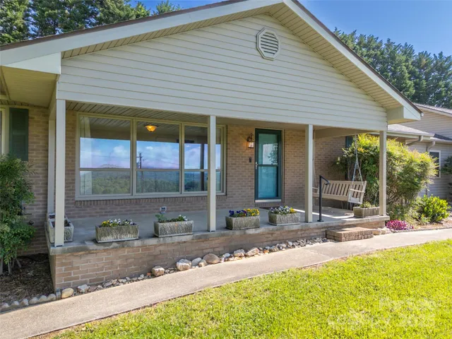 a view of a house with a yard and sitting area