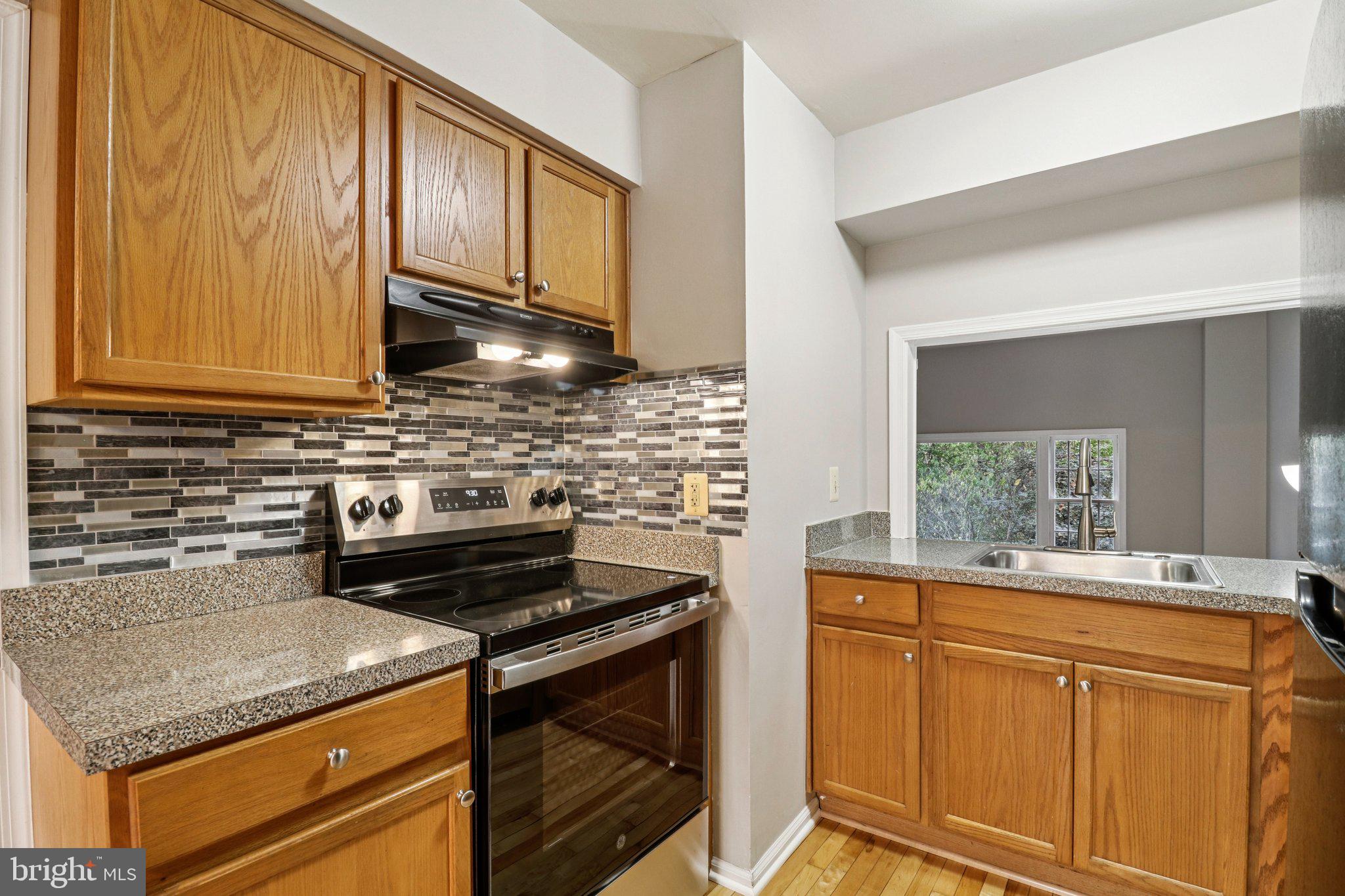 5912 Minutemen Road, Unit 295 Springfield, VA 22152 - Photo 11 of 55 a kitchen with stainless steel appliances granite countertop a sink stove and cabinets
