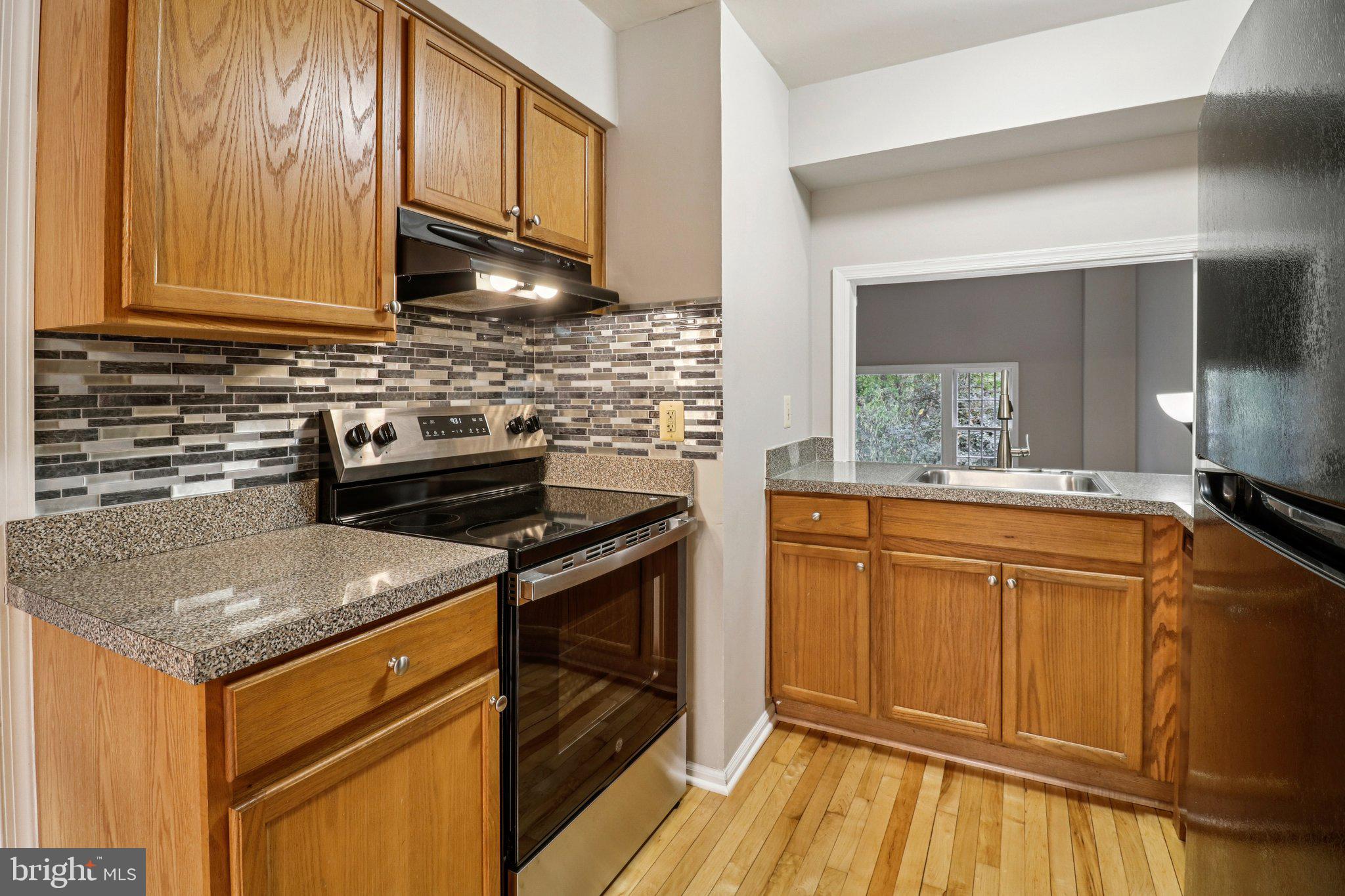 5912 Minutemen Road, Unit 295 Springfield, VA 22152 - Photo 12 of 55 a kitchen with stainless steel appliances granite countertop a sink stove and cabinets