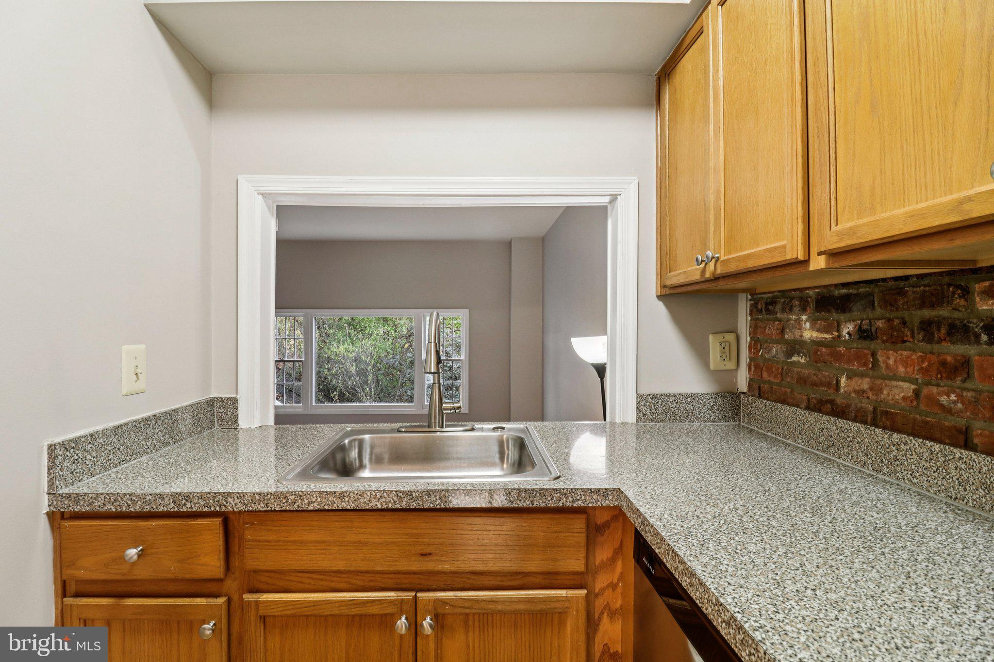 5912 Minutemen Road, Unit 295 Springfield, VA 22152 - Photo 14 of 55 a kitchen with granite countertop a sink and white cabinets