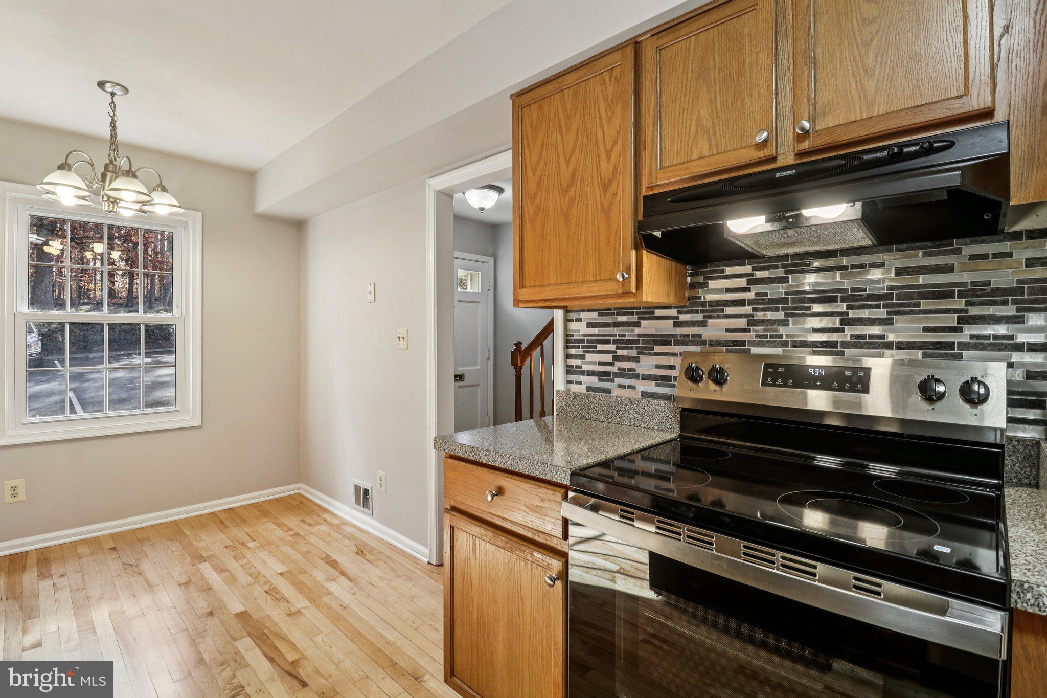 5912 Minutemen Road, Unit 295 Springfield, VA 22152 - Photo 16 of 55 a kitchen with wooden cabinets and a stove top oven