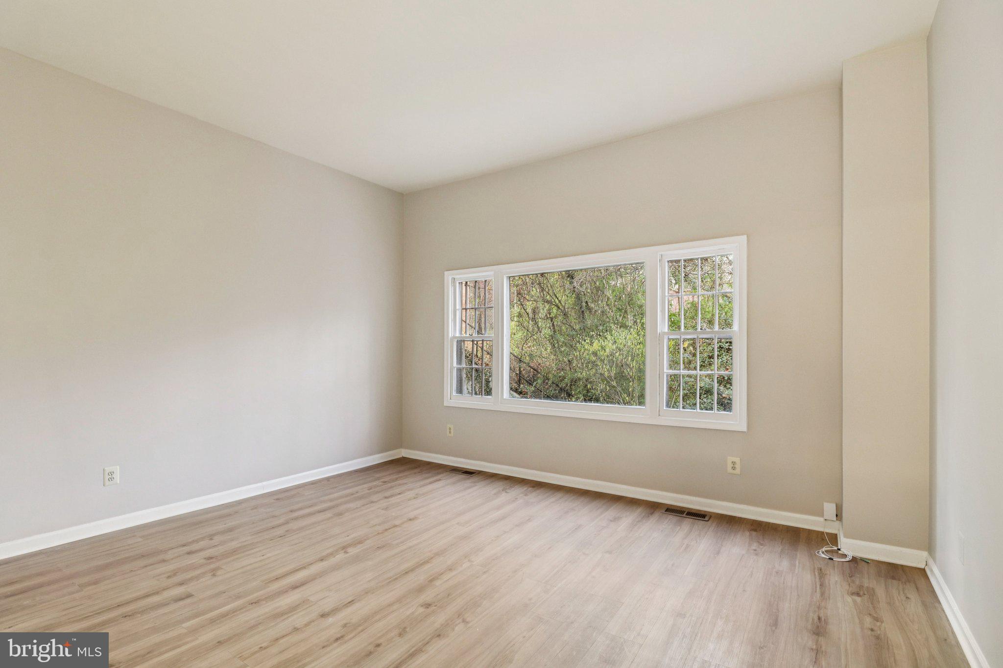 5912 Minutemen Road, Unit 295 Springfield, VA 22152 - Photo 19 of 55 an empty room with wooden floor and windows