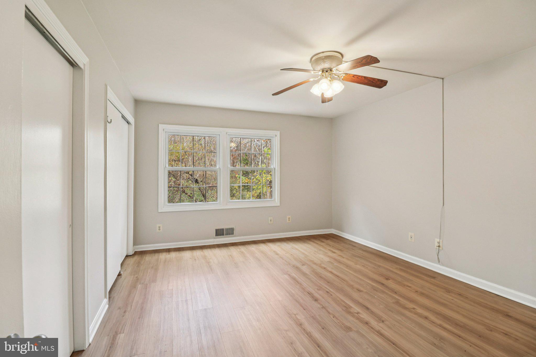 5912 Minutemen Road, Unit 295 Springfield, VA 22152 - Photo 27 of 55 an empty room with wooden floor chandelier fan and windows