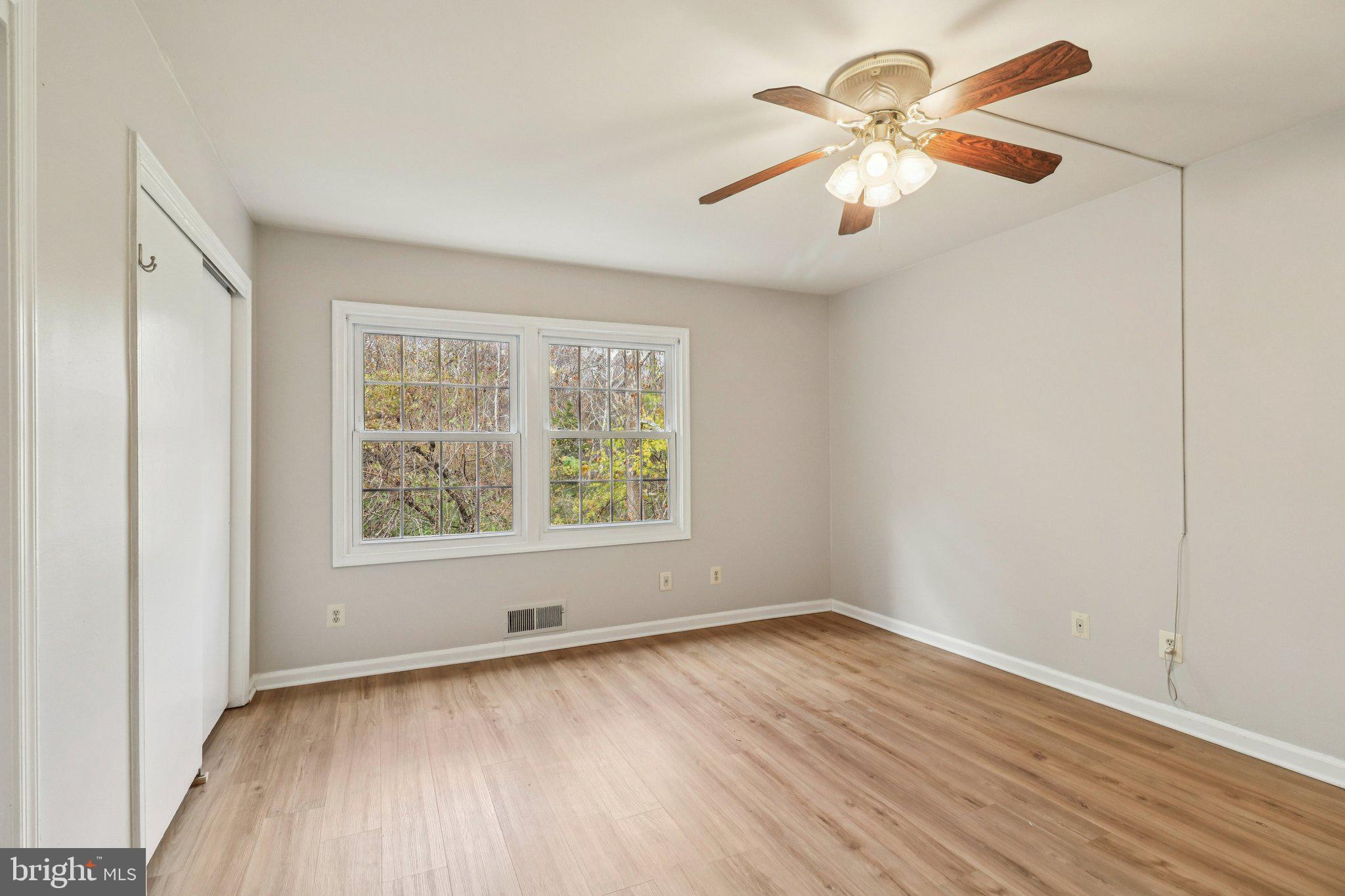 5912 Minutemen Road, Unit 295 Springfield, VA 22152 - Photo 29 of 55 an empty room with wooden floor chandelier fan and windows