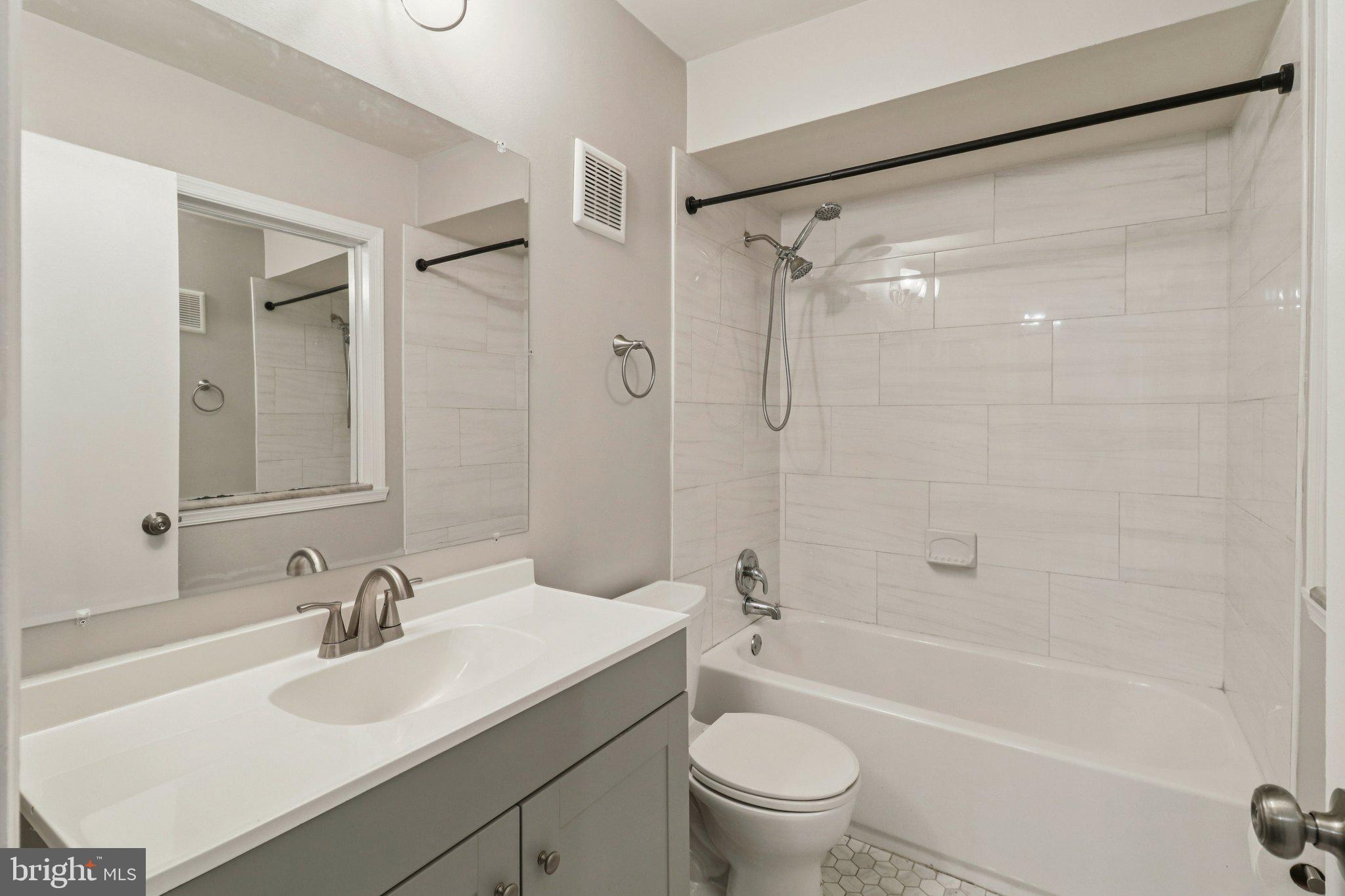 5912 Minutemen Road, Unit 295 Springfield, VA 22152 - Photo 33 of 55 a bathroom with a sink mirror toilet and bathtub