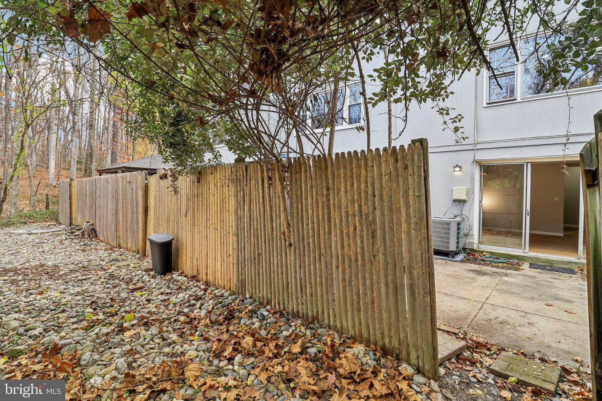 5912 Minutemen Road, Unit 295 Springfield, VA 22152 - Photo 38 of 55 a view of a house with a large tree and wooden fence