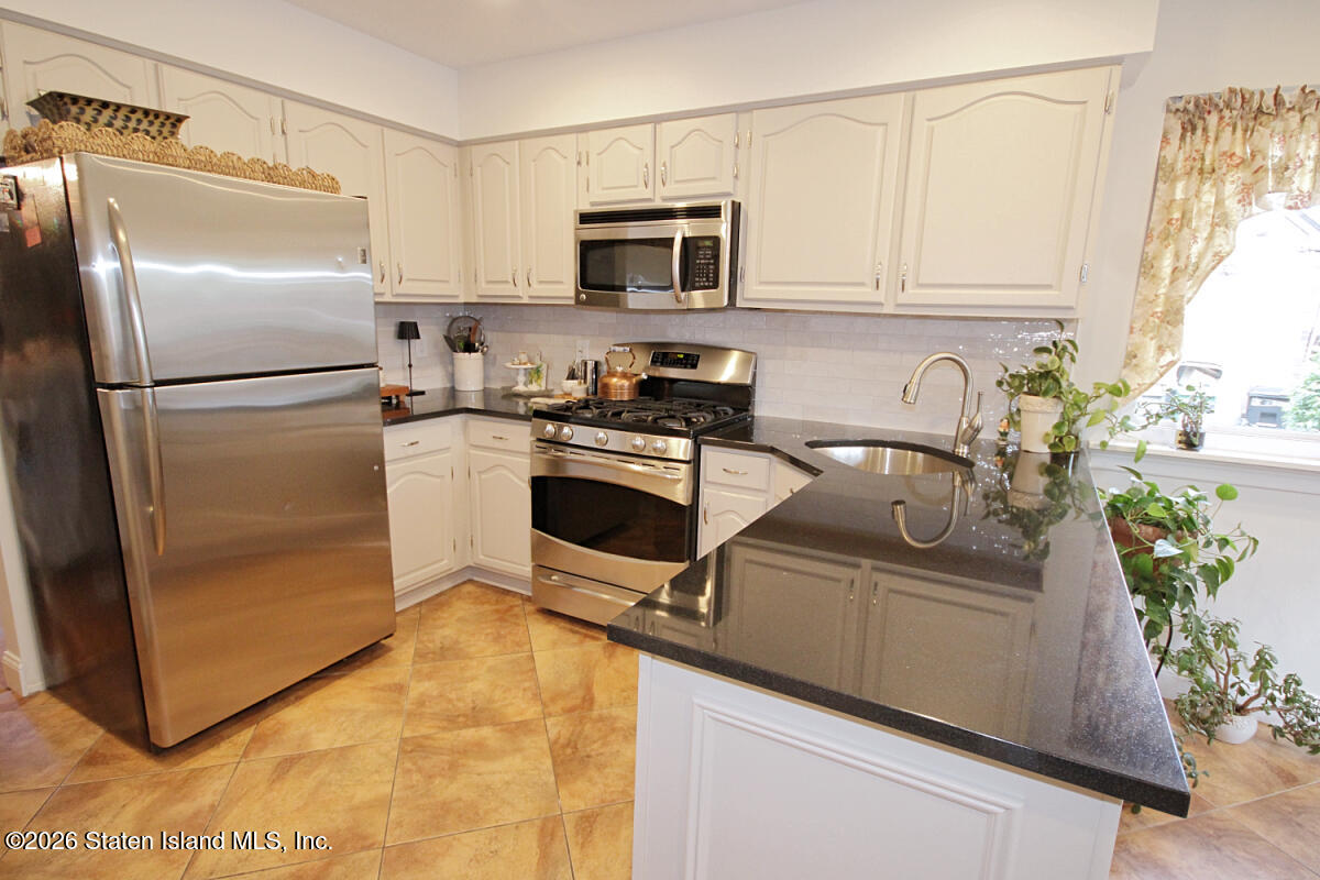 951 West Fingerboard Road Staten Island, NY 10304 - Photo 7 of 29 a kitchen with stainless steel appliances granite countertop a refrigerator a stove a sink and white cabinets