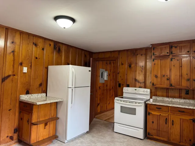 a kitchen with refrigerator a stove a sink and cabinets
