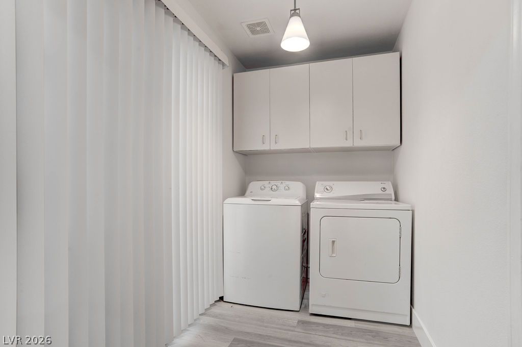 1 Rising Sun Court Henderson, NV 89074 - Photo 15 of 47 Functional laundry room featuring a washer, dryer, and ample cabinet storage.