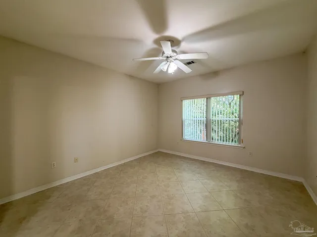 an empty room with a window and a ceiling fan