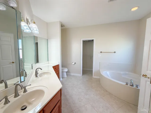 a bathroom with a tub sink and mirror