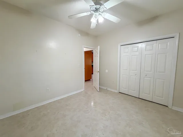 an empty room with fan and entrance