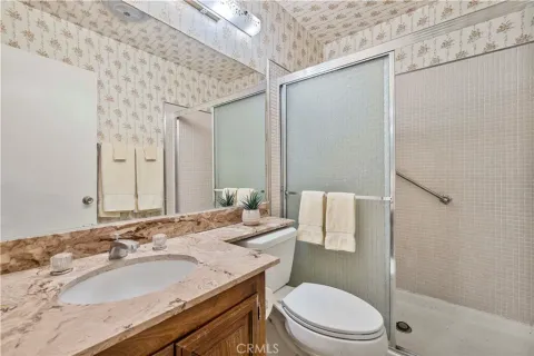 a bathroom with a granite countertop sink a toilet and a mirror