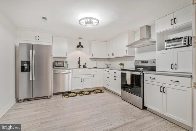 a kitchen with a stove oven and white wooden cabinets
