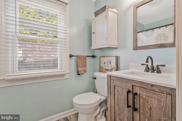 a view of a livingroom with wooden floor and a ceiling fan
