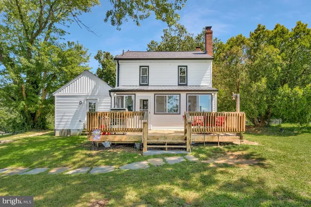 a view of a house with a big yard and large trees