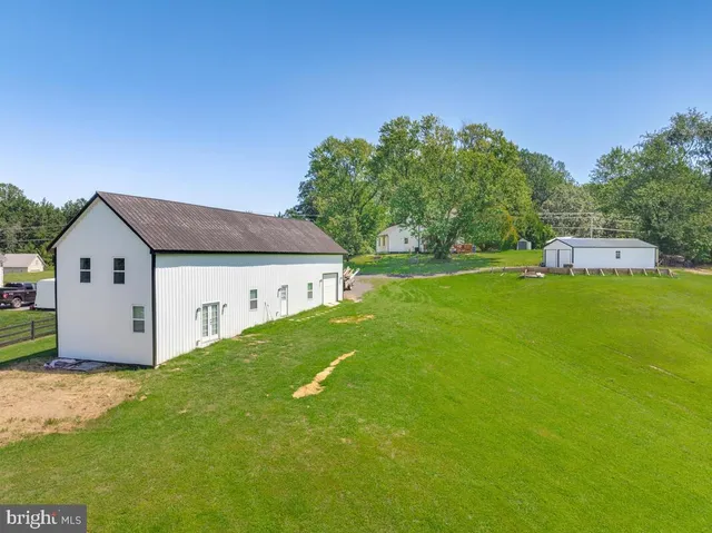 an aerial view of a residential houses with yard