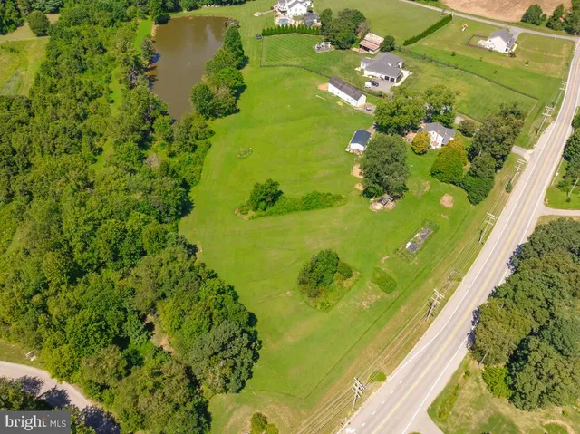 an aerial view of residential houses with outdoor space and trees