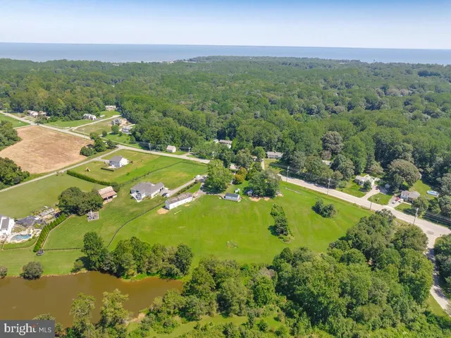 an aerial view of residential houses with outdoor space and trees