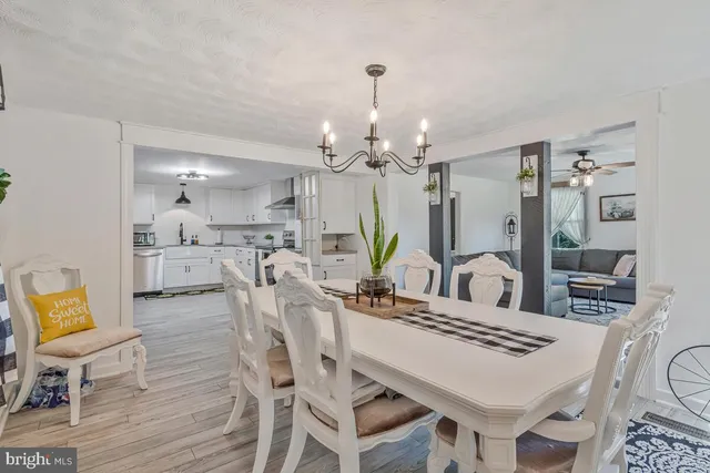 a room with stainless steel appliances kitchen island granite countertop a refrigerator and wooden cabinets