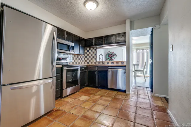 a kitchen with stainless steel appliances granite countertop a refrigerator and a sink