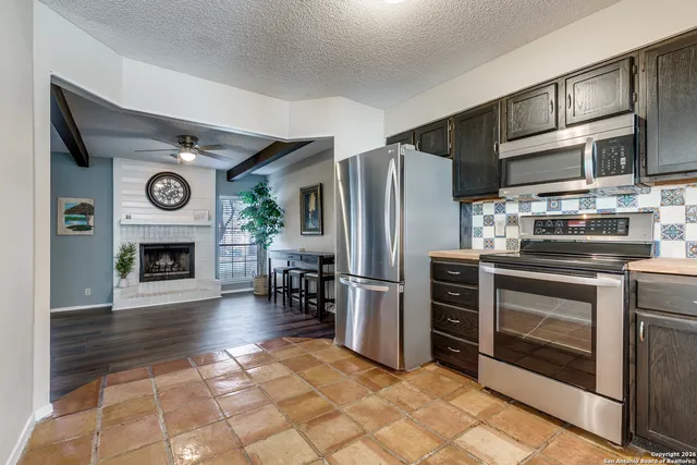 a kitchen with stainless steel appliances granite countertop a refrigerator and a stove