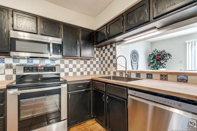 a kitchen with stainless steel appliances granite countertop a sink stove and cabinets