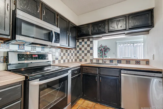 a kitchen with stainless steel appliances a stove microwave and cabinets