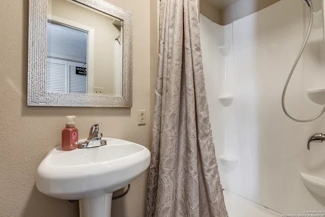 a bathroom with a sink a toilet and shower curtain