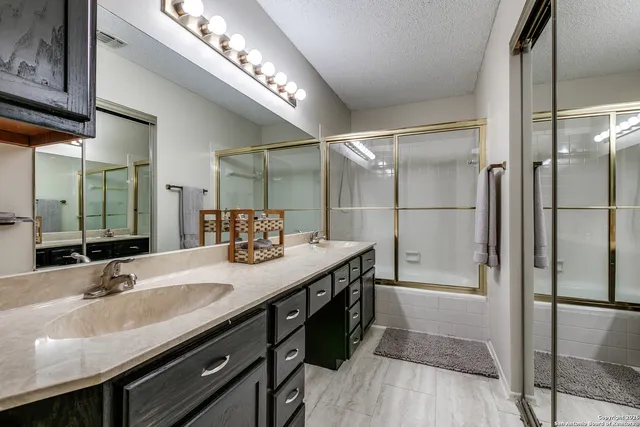 a bathroom with a granite countertop sink a toilet and shower