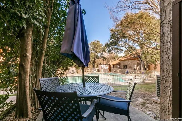 a view of a wooden chairs and table in backyard