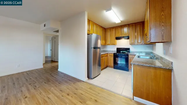 a kitchen with granite countertop wooden floors and stainless steel appliances