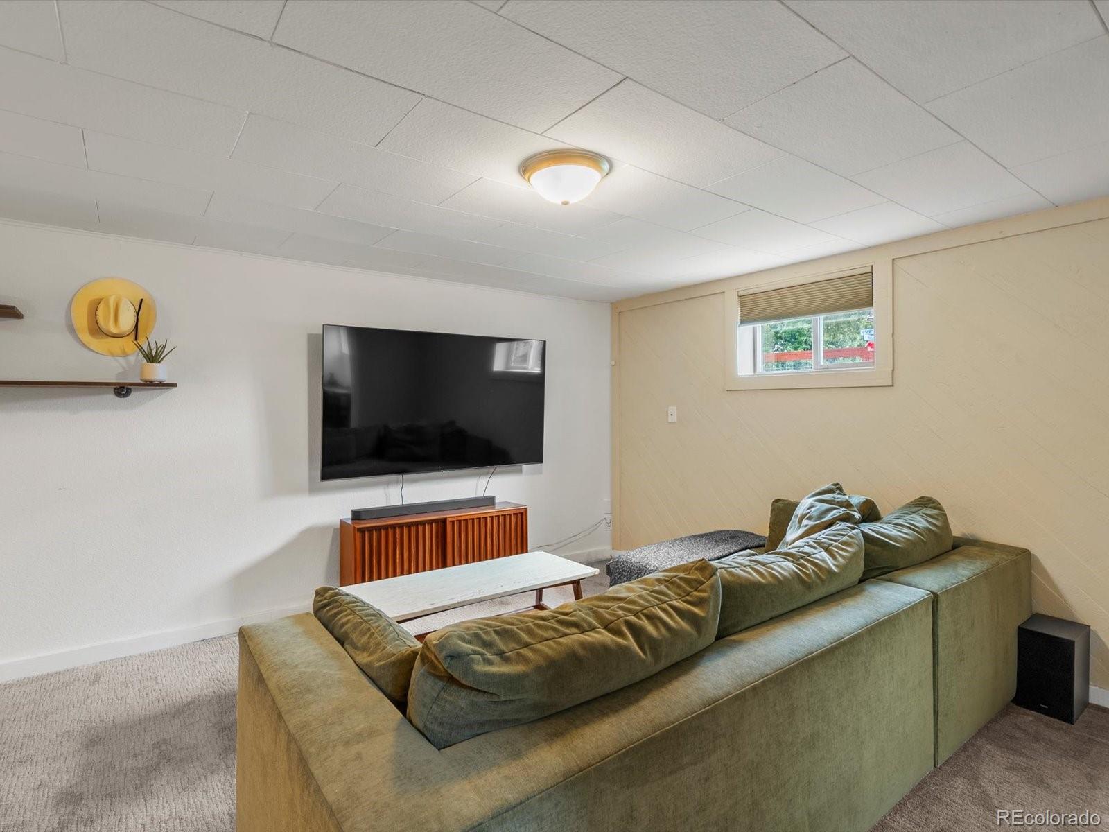 4963 North Harlan Street Wheat Ridge, CO 80033 - Photo 24 of 42 a living room with a couch and a flat screen tv
