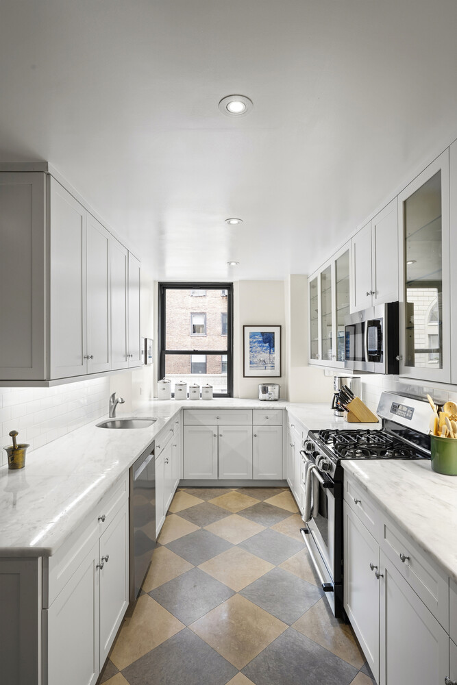 25 East 86th Street, Unit 4B Manhattan, NY 10028 - Photo 11 of 16 a kitchen with a sink stove top oven and cabinets
