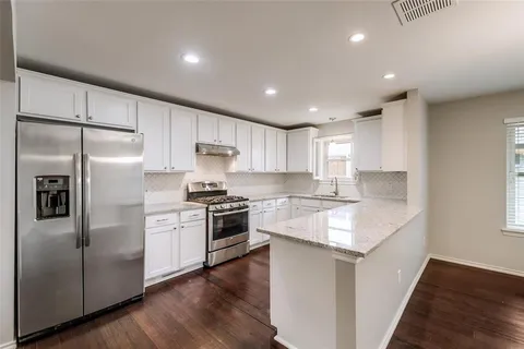 a kitchen with granite countertop appliances cabinets and a counter space