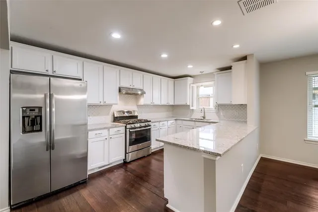 a kitchen with granite countertop appliances cabinets and a counter space