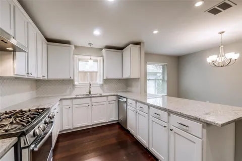 a kitchen with granite countertop white cabinets and white appliances