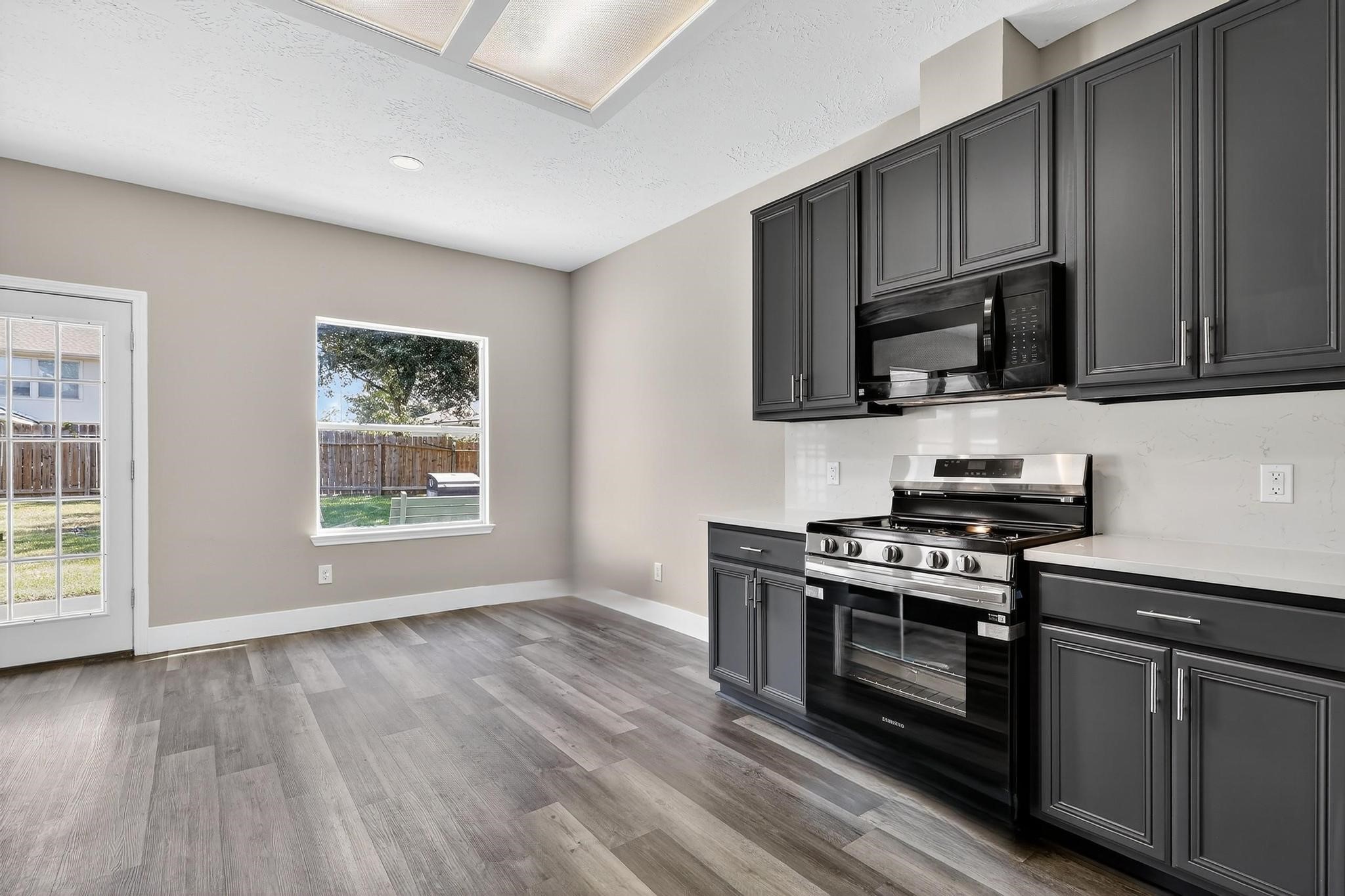 20926 Trellis Lane Houston, TX 77073 - Photo 12 of 24 a kitchen with a stove a microwave and window