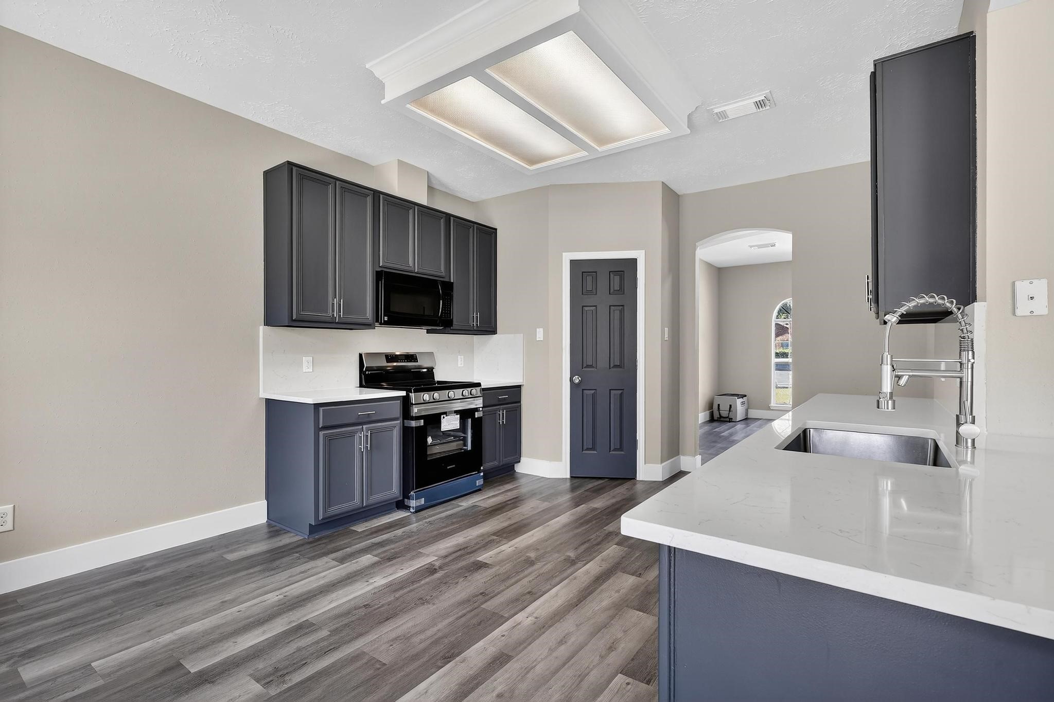 20926 Trellis Lane Houston, TX 77073 - Photo 13 of 24 a kitchen with a sink and a stove top oven with wooden floor