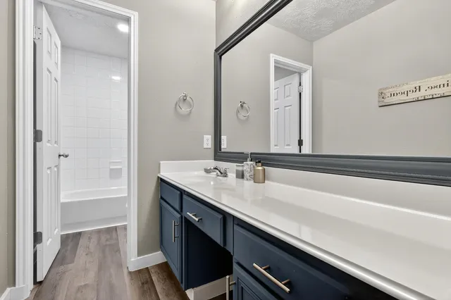 a bathroom with a sink a tub and a mirror