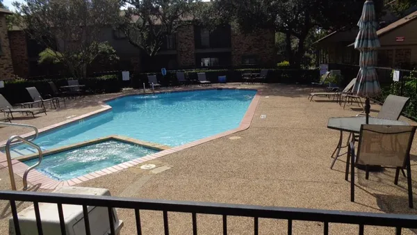a view of a swimming pool with a patio and a yard