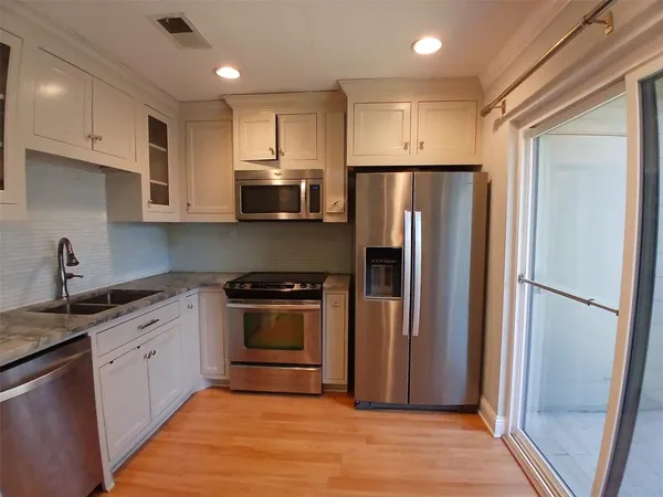 a kitchen with stainless steel appliances granite countertop a refrigerator stove and sink