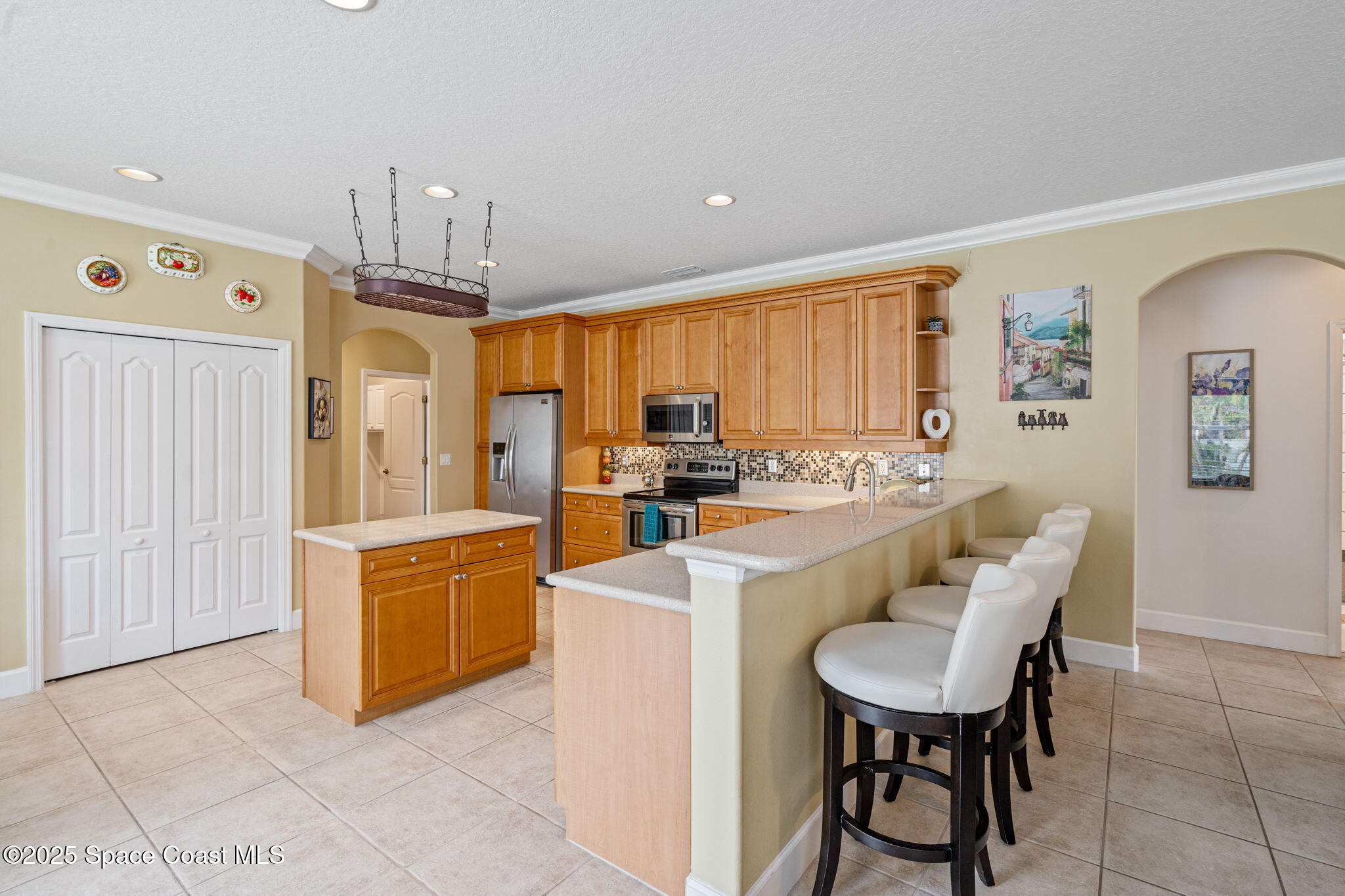 1835 Harbor Point Drive Merritt Island, FL 32952 - Photo 30 of 67 a kitchen with stainless steel appliances kitchen island granite countertop a table and chairs in it
