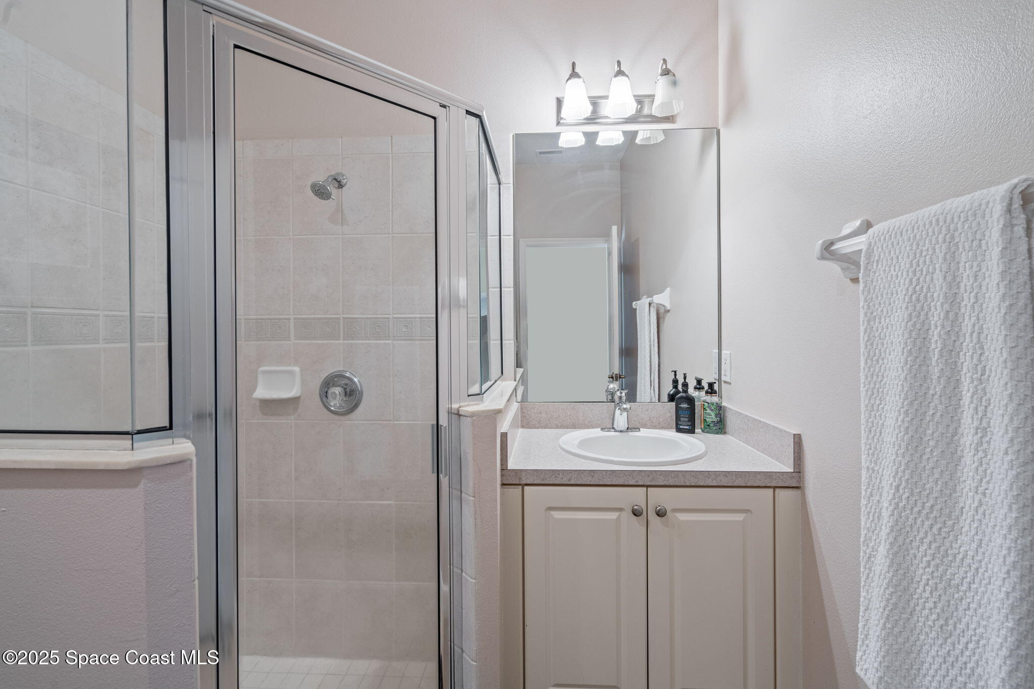 1835 Harbor Point Drive Merritt Island, FL 32952 - Photo 40 of 67 a bathroom with a sink a mirror a vanity and shower