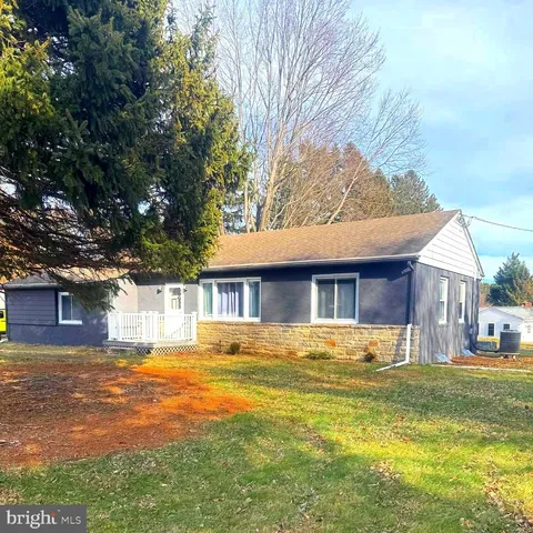 a front view of house with yard and trees around