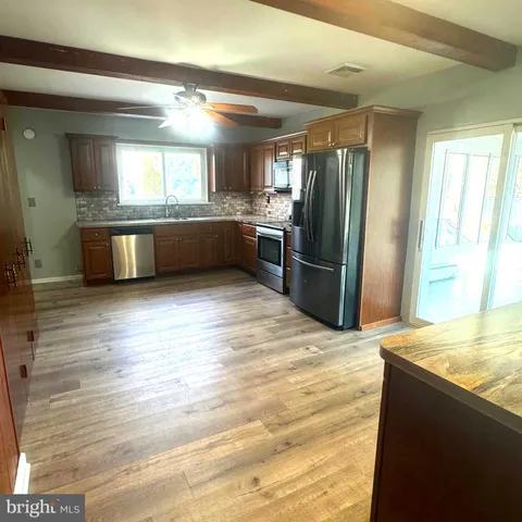 a kitchen with stainless steel appliances kitchen island granite countertop a refrigerator and a sink