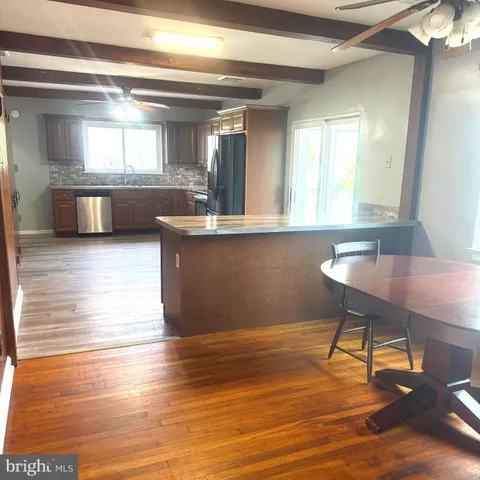 a workspace with wooden floor and a view of living room