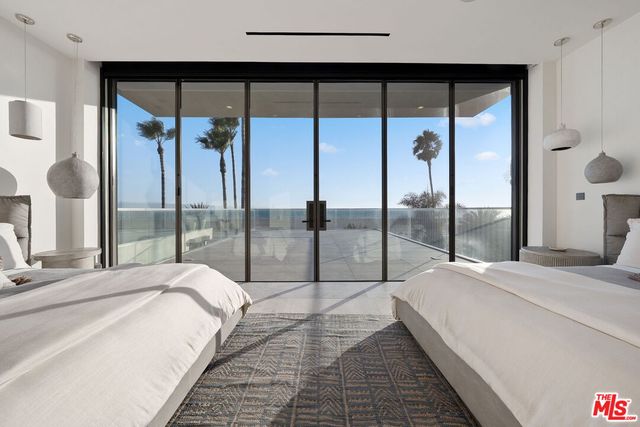 a large bedroom with a large window and a glass door